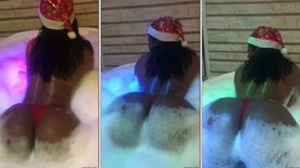 Vanessa Rodrigues in a Santa hat, rolling around in the foam bathtub
